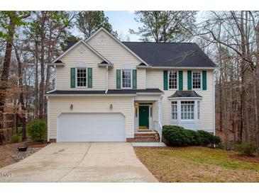 Charming two-story home featuring a green door, green shutters, and attached two-car garage at 12 Montcrest Dr, Durham, NC 27713