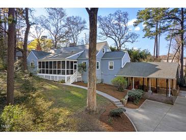 Charming home with a screened porch and covered parking, surrounded by mature trees and lush landscaping at 122 W Woodridge Dr, Durham, NC 27707