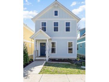Charming two-story home with light blue siding, white trim, and a welcoming front porch at 132 Fiori Hill S Dr, Hillsborough, NC 27278