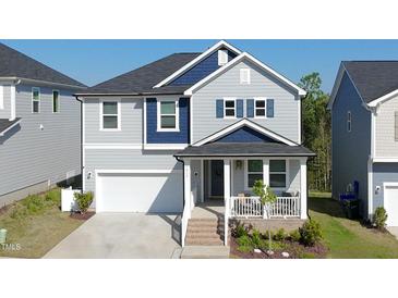 Charming two-story home with a covered front porch, attached garage, and blue and gray color scheme at 1417 Underbrush Dr, Durham, NC 27703
