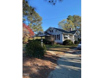 A charming home with a lush front yard, and a covered porch, perfect for enjoying the outdoors at 249 Bailey'S Crossroads Rd, Benson, NC 27504