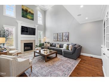 Spacious living room with a fireplace, large sectional sofa, and soaring ceilings at 2704 St Marys St, Raleigh, NC 27609