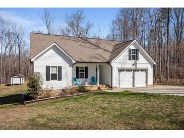 Charming exterior elevation with a two-car garage, a manicured lawn, and a cozy front porch with seating at 302 Weaver Ridge Rd, Rougemont, NC 27572