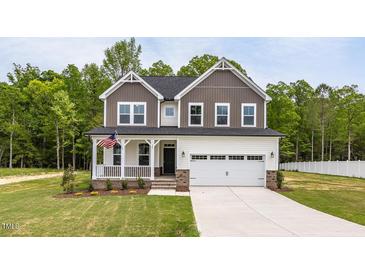 Charming two-story home featuring a welcoming front porch and a two-car garage at 303 Old Fashioned Way, Lillington, NC 27546