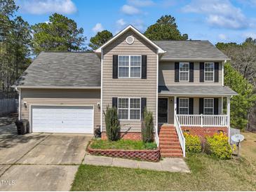 Charming two-story home featuring neutral siding, black shutters, and an attached two-car garage at 325 Cobblestone Dr, Spring Lake, NC 28390