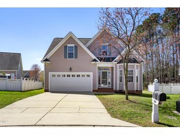 Charming two-story home with a well-manicured lawn, two-car garage, and a cozy front porch at 4005 Freesia Ct, Zebulon, NC 27597