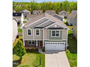 Two-story home featuring a two-car garage, a mix of siding, stone accents, and a well-maintained lawn at 417 Sapphire Rd, Burlington, NC 27215