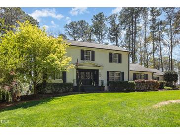 Charming two-story home featuring a well-manicured lawn, white brick, and black shutters at 509 Queensferry Rd, Cary, NC 27511