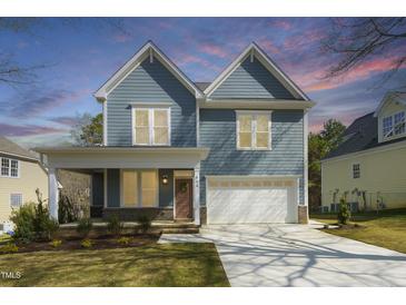 Charming two-story home with light blue siding, a two-car garage and a well-manicured lawn at 604 Whistable Ave, Wake Forest, NC 27587