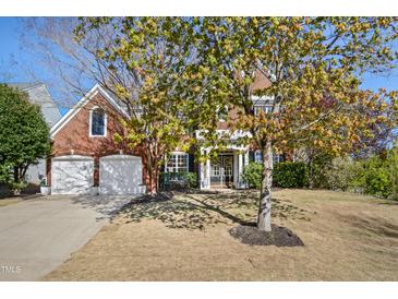 Charming red brick home with a well-manicured lawn, two car garage, and inviting front entrance at 7604 Derek Dr, Raleigh, NC 27613