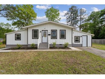 Charming home featuring a well-maintained lawn and a welcoming front porch with gray trim at 1001 Helms Pl, Raleigh, NC 27610