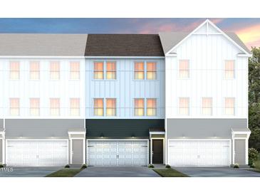 New townhome construction featuring white and light-blue siding, attached garage, and a classic design at 1502 Tamarisk Ln, Durham, NC 27703