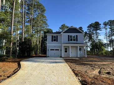 Charming two-story home featuring a one-car garage, a welcoming porch and a neatly paved driveway at 187 Regis Ln # 10, Coats, NC 27521
