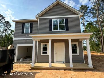 Charming two-story home with gray siding, black shutters, and a welcoming front porch with white columns at 205 Regis Ln # 11, Coats, NC 27521