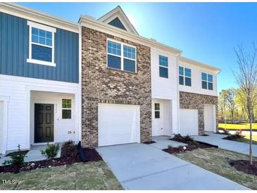 Charming townhome with attached garages, lovely brick and siding accents and a well manicured lawn at 2123 Trailside Dr, Durham, NC 27704