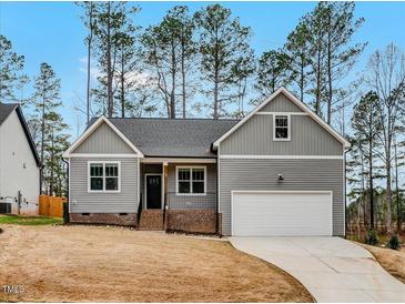 Charming new construction home with gray siding, a front porch, and an attached garage at 220 Shawnee Dr, Louisburg, NC 27549