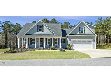Charming home featuring a manicured lawn, stone accents, and a welcoming front porch with classic architectural details at 236 Star Valley Dr, Angier, NC 27501