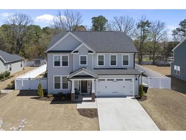 Charming two-story home with a well-manicured lawn, a two-car garage, and a welcoming front porch at 239 Hopper Cir, Clayton, NC 27520