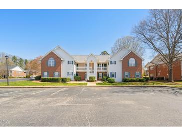 Exterior view of brick and white condo building with blue shutters and a well-maintained landscape at 2621 Wellington Ridge Loop, Cary, NC 27518