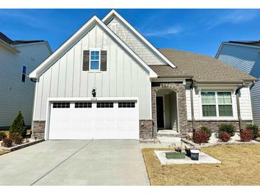 Charming home featuring stone accents, neutral siding, a well-manicured lawn and an attached two-car garage at 2918 Balbardie Dr, Apex, NC 27502