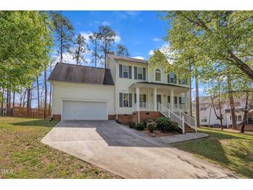 Charming two-story home featuring a welcoming front porch, attached garage, and beautifully landscaped yard at 3 Guilder Cv, Durham, NC 27713