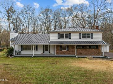Charming two-story home with a metal roof and inviting front porch at 315 Dumont Dr, Hillsborough, NC 27278