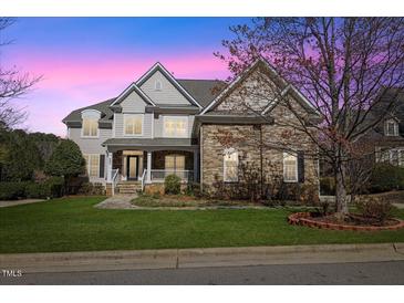 Charming two-story home featuring a landscaped front yard, stone accents, and a welcoming front porch at 404 Vintage Hill Cir, Apex, NC 27539