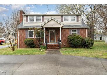Charming brick home featuring a classic design, well-maintained lawn, and inviting curb appeal at 413 S Maple St, Graham, NC 27253