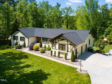 Well-maintained single-story home with a lush green lawn, mature trees, and an attached two-car garage at 5313 Edington Ln, Raleigh, NC 27604