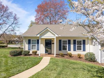 Charming home featuring blue shutters, a manicured lawn, and blooming trees creating curb appeal at 6817 Fairpoint Ct, Raleigh, NC 27613