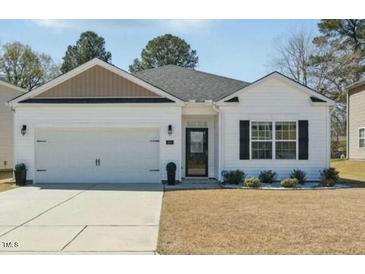 Charming single-story home with white siding, black shutters, and well-maintained lawn at 909 Sea Holly Dr, Zebulon, NC 27597