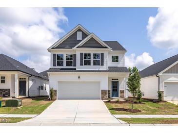 Charming two-story home with a two-car garage, gray accents, and a well-manicured lawn at 104 Fairwinds Dr, Lillington, NC 27546