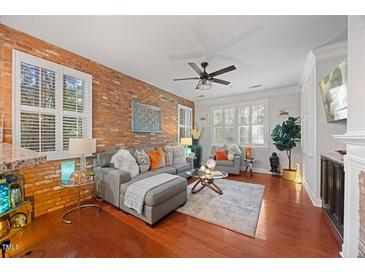 Inviting living room featuring a brick accent wall and plush grey sectional at 10400 Rosegate Ct # 3, Raleigh, NC 27617