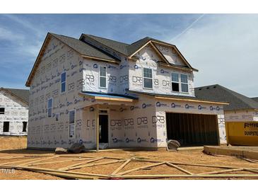 Two-story home under construction showcasing a modern design with a covered porch and attached garage at 1049 Channel Drop Lp, Zebulon, NC 27597