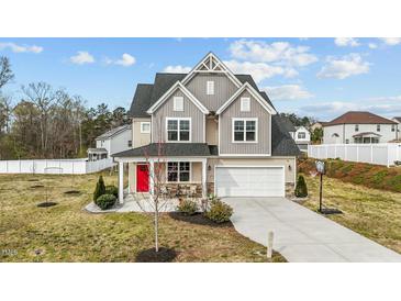 Beautiful two-story home featuring gray and tan siding, covered front porch and well-manicured landscaping at 118 Lockhaven Dr, Garner, NC 27529