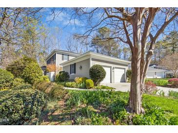 Charming two-story home with a well-maintained lawn, lovely landscaping, and attached two-car garage at 1309 Langdon Pl, Pittsboro, NC 27312