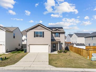 Charming two-story home featuring a two-car garage and neutral siding, complemented by a well-maintained lawn at 1445 Lombar St, Raleigh, NC 27610