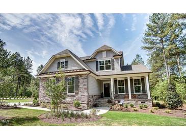 Charming two-story home featuring stone accents, gray siding, well-manicured lawn, and mature trees at 150 Green Haven Blvd # 67, Youngsville, NC 27596