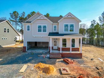 Two-story home with a covered front porch and an attached two-car garage, set on a partially cleared lot at 217 Duncan Creek Rd # 124, Lillington, NC 27546