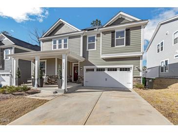 Charming two-story home featuring a two-car garage, landscaped front yard, and covered front porch at 3360 Brevet St, New Hill, NC 27562