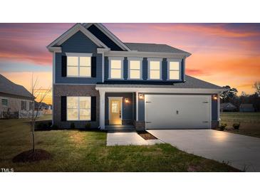 Charming two-story home with blue siding, brick accents, and a yellow front door under a beautiful sunset sky at 75 Eltham, Rocky Mount, NC 27804