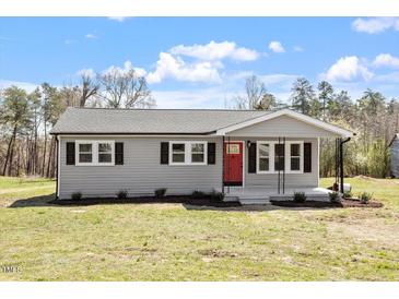 Charming single-story home featuring a red front door and neatly landscaped yard at 8215 S Nc 119 Hwy, Mebane, NC 27302