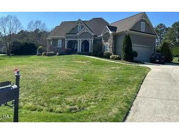 Charming home with manicured lawn, beautiful landscaping, and a welcoming front porch at 1101 Dovefield Ln, Youngsville, NC 27596