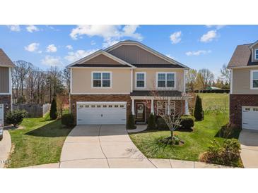 Charming two-story home featuring a manicured front yard and a two-car garage at 1295 Kerr St, Burlington, NC 27215