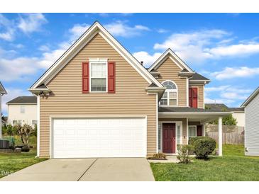 Charming two-story home with tan siding, red shutters, white trim, and a spacious two-car garage at 1320 Rushing Creek Pkwy, Raleigh, NC 27610