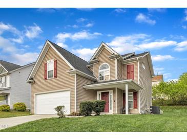 Charming two-story home with a well-manicured lawn, attached garage, and red accents on the shutters and front door at 1320 Rushing Creek Pkwy, Raleigh, NC 27610