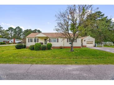 Charming single-story home with a well-maintained lawn and attached garage; perfect for suburban living at 200 N 9Th St, Erwin, NC 28339