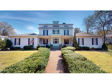 Charming two-story home featuring a manicured lawn, inviting walkway, and classic architectural details at 238 N Main St, Wake Forest, NC 27587
