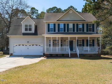 Charming two-story home with a large front porch, attached garage, and well-maintained lawn at 382 Tomahawk Dr, Clayton, NC 27520