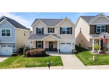 Charming two-story home with manicured lawn, attached garage, and welcoming front porch at 4044 Dunkirk Dr, Burlington, NC 27215